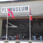 Flymuseet med flagg og åpen port.