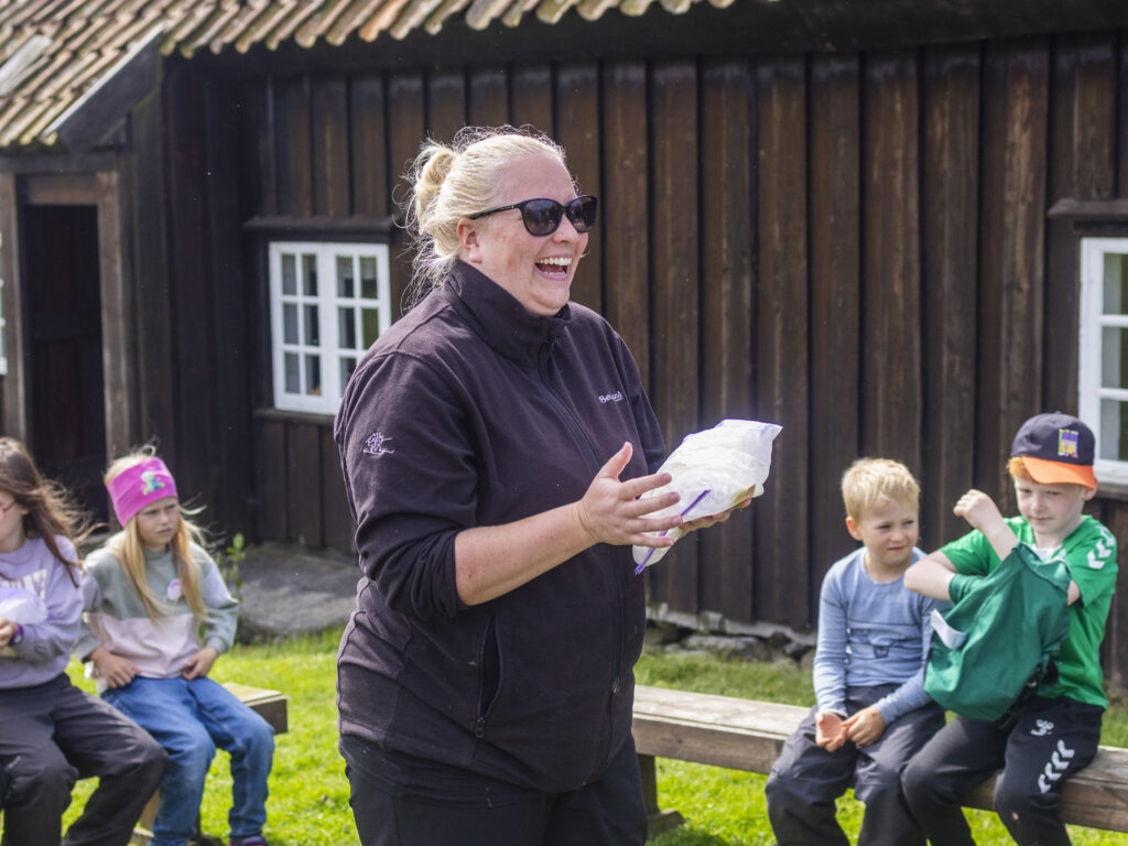 Formidlar med skuleklasse framfor løa