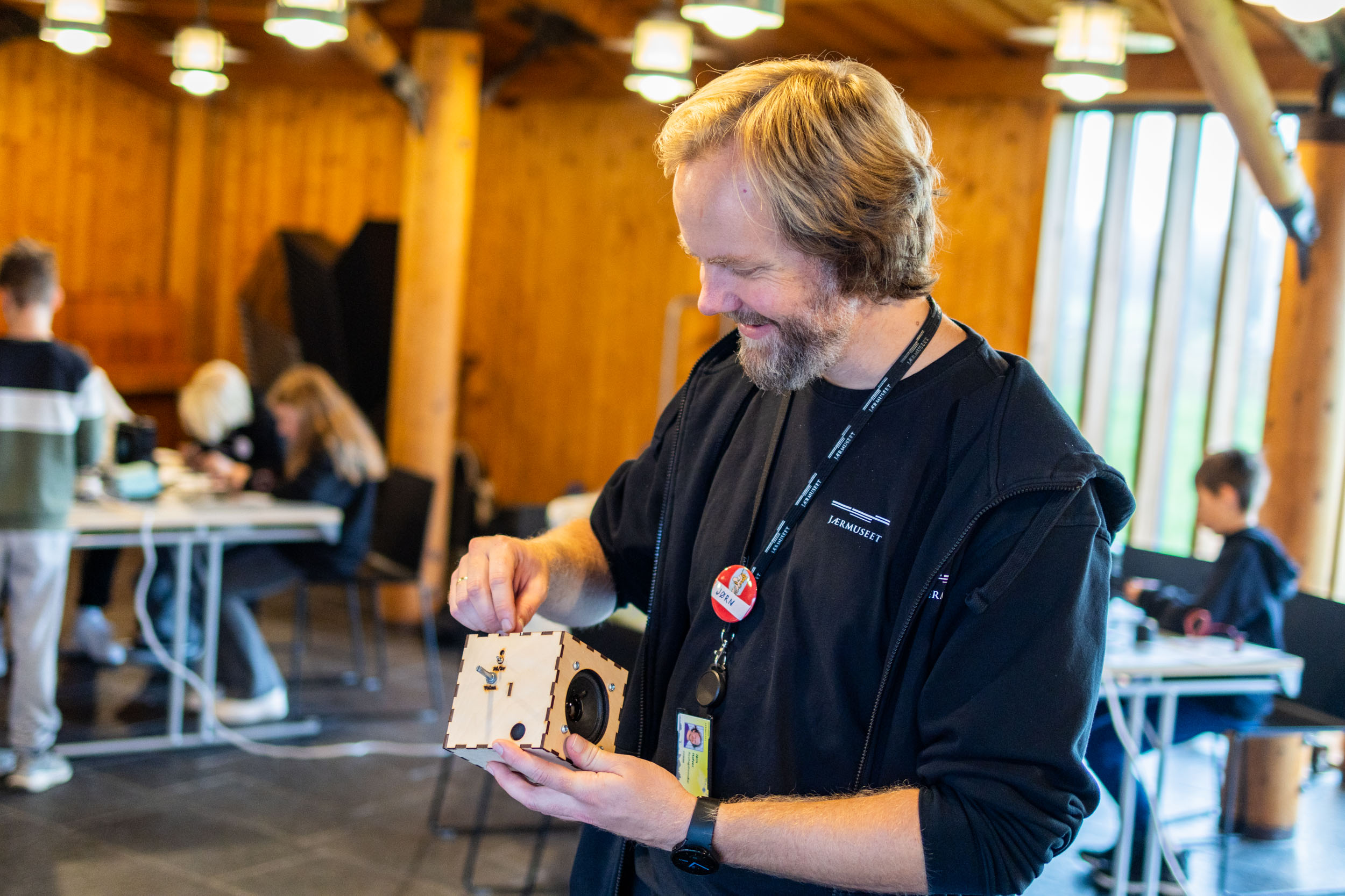 Jørn Hafver, realfagsformidlar smile medan han ser på bluetooth høgtalaran som han held i henda.